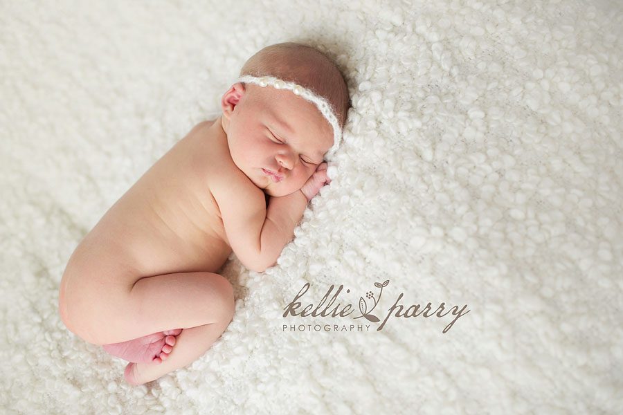 newborn baby girl on white blanket