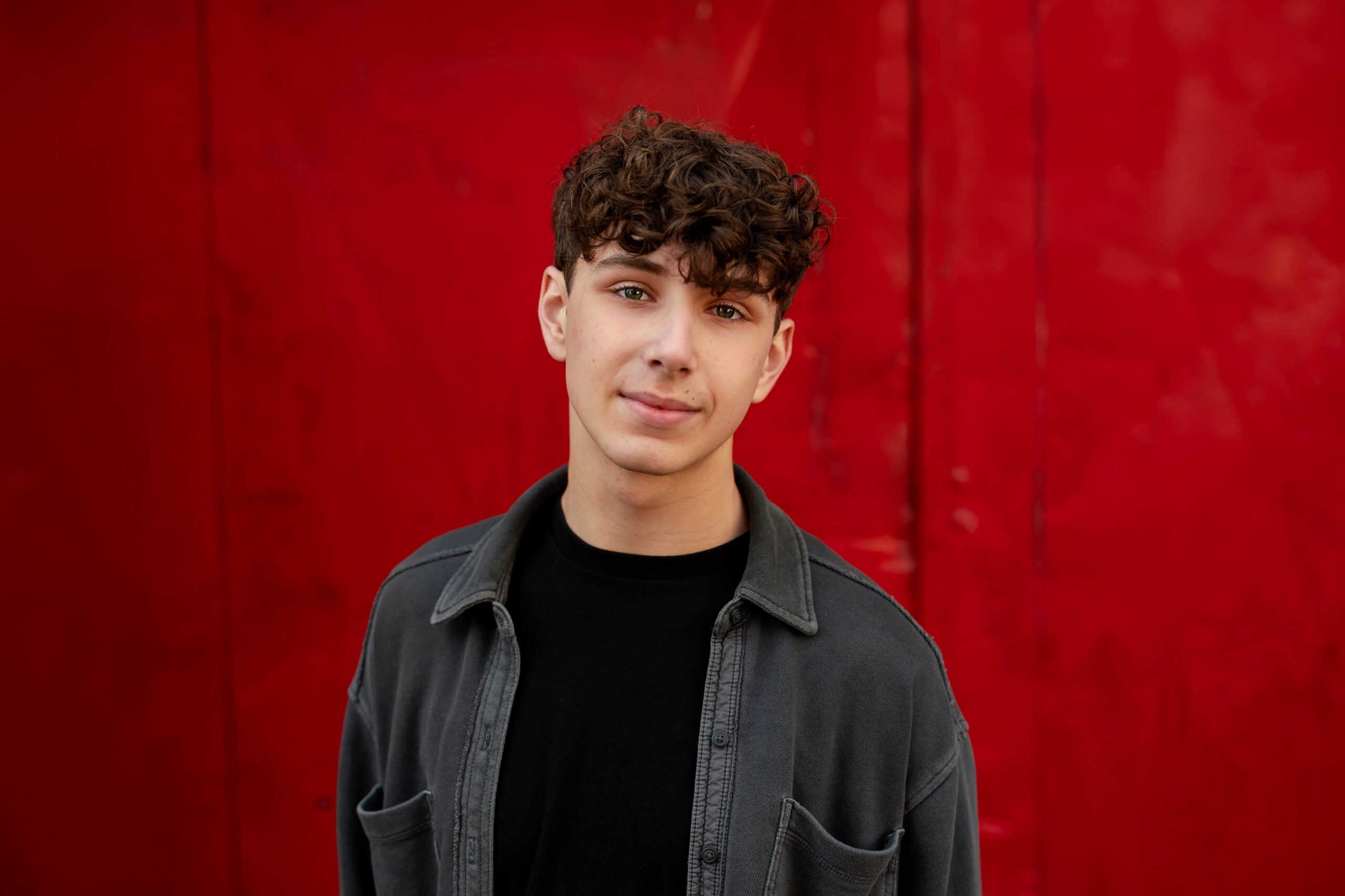 senior photo of a boy with red background in Salem, OR